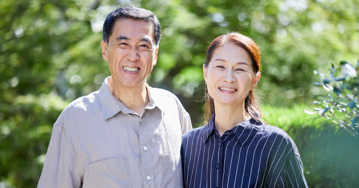 一對中老年夫妻在戶外並肩微笑